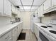 Well-lit galley kitchen with white cabinets, appliances, and modern flooring for a clean and inviting space at 11251 80Th Ave # 305, Seminole, FL 33772