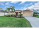 Charming single-story home with a well-manicured lawn, palm trees, and a two-car garage at 11835 Hollyhock Dr, Lakewood Ranch, FL 34202