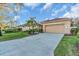 Exterior view of home featuring an attached two-car garage and mature landscaping at 11835 Hollyhock Dr, Lakewood Ranch, FL 34202