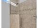 Close-up of a tiled walk-in shower featuring updated fixtures, and a decorative accent tile at 11835 Hollyhock Dr, Lakewood Ranch, FL 34202