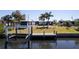 Waterfront backyard featuring a dock, boat lift, lush lawn, and easy access to water activities at 125 Palmetto Ne Cir, Port Charlotte, FL 33952