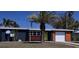 Charming single-story home with a well-manicured lawn, a palm tree, and a pop of color with the front door at 125 Palmetto Ne Cir, Port Charlotte, FL 33952