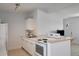 Well-lit kitchen with white appliances and cabinets, complemented by a light wood breakfast bar at 125 Palmetto Ne Cir, Port Charlotte, FL 33952