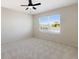 Carpeted bedroom with ceiling fan and a large window overlooking a serene lake view at 12533 Night View Dr, Sarasota, FL 34238