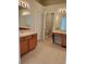 Primary bathroom with double vanity, tiled floor, and separate door to the water closet at 13338 Evening Sunset Ln, Riverview, FL 33579