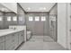 Contemporary bathroom featuring gray tile, dual vanity sinks, glass enclosed shower and a standalone tub at 17907 Palmiste Dr, Bradenton, FL 34202