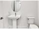 This half bathroom is equipped with a pedestal sink and elongated oval mirror at 17907 Palmiste Dr, Bradenton, FL 34202