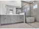 Modern bathroom featuring double vanity, gray cabinets, standalone tub, and glass enclosed shower at 17907 Palmiste Dr, Bradenton, FL 34202