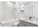 This bright bathroom features white subway tiles, a tub with a shower, and a gray vanity at 17907 Palmiste Dr, Bradenton, FL 34202