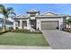 Beautiful single-story home with manicured lawn, lovely landscaping, paver driveway, and a two-car garage at 17907 Palmiste Dr, Bradenton, FL 34202