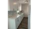 Modern kitchen featuring white cabinets, quartz countertops, mosaic backsplash and wood flooring at 1804 Bayshore Gardens Pkwy, Bradenton, FL 34207