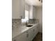 Updated kitchen showcasing white cabinetry, quartz countertops, mosaic backsplash, and wood flooring at 1804 Bayshore Gardens Pkwy, Bradenton, FL 34207