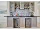 Stylish bar area with custom cabinetry, mosaic backsplash, and beverage refrigerators at 18113 Gawthrop Dr # 103, Bradenton, FL 34211