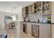 Close up of bar area with tiled backsplash, wine cooler, and views of the dining area at 18113 Gawthrop Dr # 103, Bradenton, FL 34211