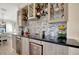 Elegant wet bar with black countertops, stylish backsplash, and cabinet storage for drinks and glassware at 18113 Gawthrop Dr # 103, Bradenton, FL 34211