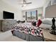 Bedroom features a large window, desk, ceiling fan, and geometric patterned comforter at 18113 Gawthrop Dr # 103, Bradenton, FL 34211