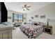 Bedroom features a large window, desk, ceiling fan, and geometric patterned comforter at 18113 Gawthrop Dr # 103, Bradenton, FL 34211