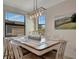 Bright dining room featuring a large window and a stylish rectangular chandelier above the dining table at 18113 Gawthrop Dr # 103, Bradenton, FL 34211