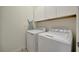 Clean laundry room with washer, dryer, and white storage cabinets above machines at 18113 Gawthrop Dr # 103, Bradenton, FL 34211