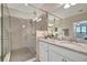 Well-lit bathroom with granite counters, dual sinks and modern walk-in shower at 18113 Gawthrop Dr # 103, Bradenton, FL 34211