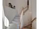 Carpeted staircase with wood railing leading to the upper level of the home at 18113 Gawthrop Dr # 103, Bradenton, FL 34211