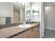 Bathroom with gray wood-look tile, dark granite countertop, modern sink, and a large mirror at 2021 Central Ave, Sarasota, FL 34234