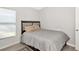 Modest bedroom with wood-look tile flooring, a large window, and a queen-size bed with pillows at 2021 Central Ave, Sarasota, FL 34234