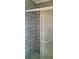 Close up of a shower with horizontal wood-look tiles, chrome shower head, and frosted glass door detail at 2021 Central Ave, Sarasota, FL 34234