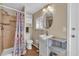 Bright bathroom featuring a shower, vanity with storage, oval mirror and wood-look floors at 2207 Holyoke Ave, Bradenton, FL 34207