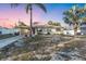Cozy single-story home features a charming carport, attractive white fencing and mature landscaping with two palm trees at 2207 Holyoke Ave, Bradenton, FL 34207