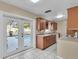 Traditional kitchen features warm wood cabinetry and white tile flooring leading to the beautiful pool area at 2207 Holyoke Ave, Bradenton, FL 34207
