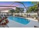 A relaxing in-ground pool inside a screened enclosure and surrounded by a patio with chairs at 2207 Holyoke Ave, Bradenton, FL 34207