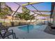 A beautiful in-ground pool inside a screened enclosure with outdoor seating at 2207 Holyoke Ave, Bradenton, FL 34207