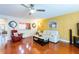 Bright living room with wood floors, yellow walls, and views into the kitchen and sunroom at 2409 Gun Flint Trl, Palm Harbor, FL 34683