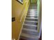 Carpeted stairs with yellow wall and white handrail leading up to the next level at 2409 Gun Flint Trl, Palm Harbor, FL 34683