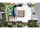 Aerial view of backyard featuring a pool, lush landscaping, a thatch cabana, and a private boat dock at 244 Willow Ave, Anna Maria, FL 34216