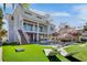 Luxury backyard with a modern outdoor kitchen, lounge chairs, and a pool, offering a perfect blend of relaxation and entertainment at 244 Willow Ave, Anna Maria, FL 34216