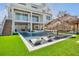 Beautiful backyard featuring a pool, tiki hut, lounge chairs, and lush green lawn, perfect for outdoor entertaining and relaxation at 244 Willow Ave, Anna Maria, FL 34216