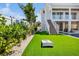 Manicured backyard with a corn hole game and lush landscaping, offering a perfect space for outdoor enjoyment and relaxation at 244 Willow Ave, Anna Maria, FL 34216