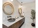 Elegant powder room features dual vessel sinks, white marble counters and unique round framed mirrors at 244 Willow Ave, Anna Maria, FL 34216