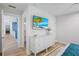 Open bedroom with a beach view TV, dresser, and doorway to a bathroom at 244 Willow Ave, Anna Maria, FL 34216
