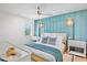 Stylish bedroom featuring a blue accent wall, ceiling fan, and plush bedding with lots of natural light at 244 Willow Ave, Anna Maria, FL 34216