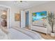Inviting bedroom with a light color palette, decorative wall art, and TV above a console table at 244 Willow Ave, Anna Maria, FL 34216