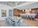 Dining room with a kitchen area, featuring seating for eight and modern decor at 244 Willow Ave, Anna Maria, FL 34216