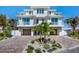 Stunning waterfront home boasting a private brick driveway, mature palms, and dual wooden garage doors at 244 Willow Ave, Anna Maria, FL 34216