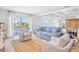 Bright living room with striped furniture, jute rug, coffered ceilings, and sliding doors to outdoor space at 244 Willow Ave, Anna Maria, FL 34216