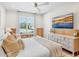 Bright primary bedroom featuring stylish decor, a large window, and a mounted flatscreen TV at 244 Willow Ave, Anna Maria, FL 34216