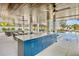 Entertain in this great outdoor kitchen with a large island, seating, and a swimming pool view at 244 Willow Ave, Anna Maria, FL 34216