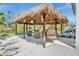 Relaxing tiki hut featuring comfortable seating and hanging chairs near the inviting pool at 244 Willow Ave, Anna Maria, FL 34216