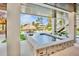 Covered patio with an outdoor spa and pool views, offering a tranquil retreat for relaxation and rejuvenation at 244 Willow Ave, Anna Maria, FL 34216
